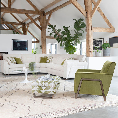 Corner sofa in vaulted ceiling lounge.  Sofa in pale beige with deep lime green accent chair with ash wood legs.