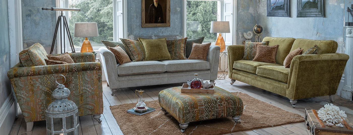 Living room with patterned armchair, sofa, and ottoman in a home setting.