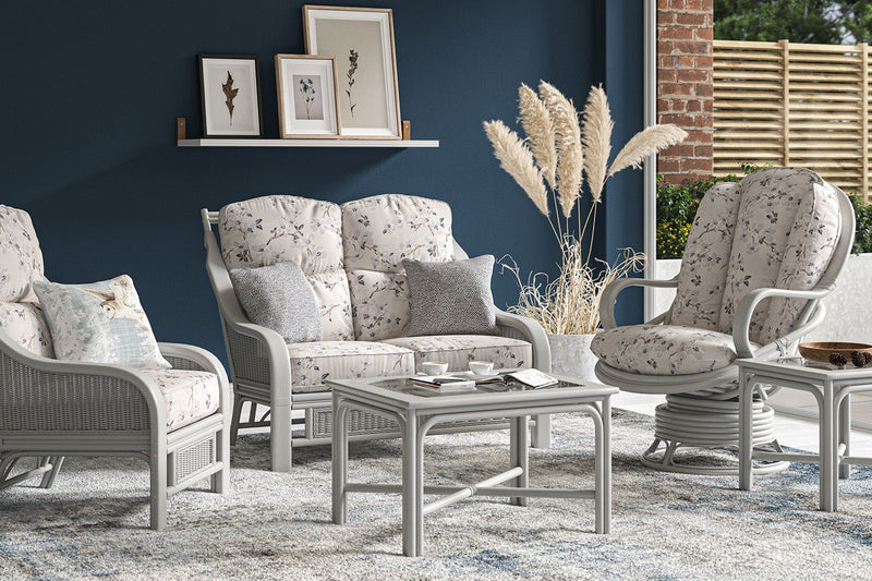 Conservatory seating set in grey with patterned cushions.